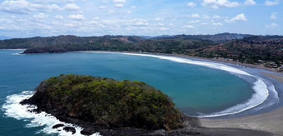 Aerial view of the Playa Venao bay with the forested headland in the foreground
